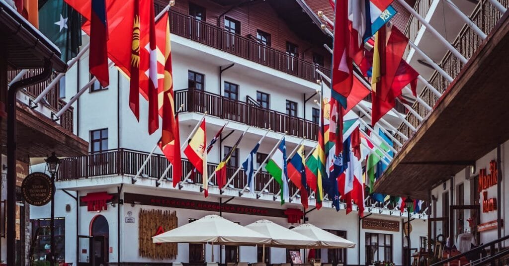 A lively urban street adorned with colorful international flags and modern architecture.
