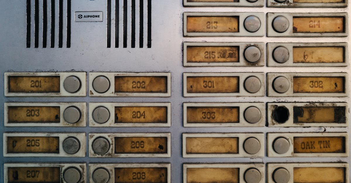 Close-up of an old, worn-out apartment intercom panel with buttons and numbers.