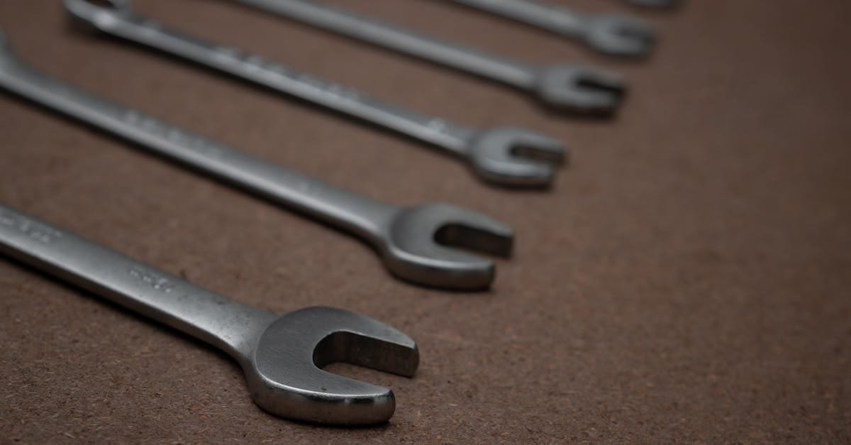 A detailed photo of silver metallic spanners laid on a brown surface.