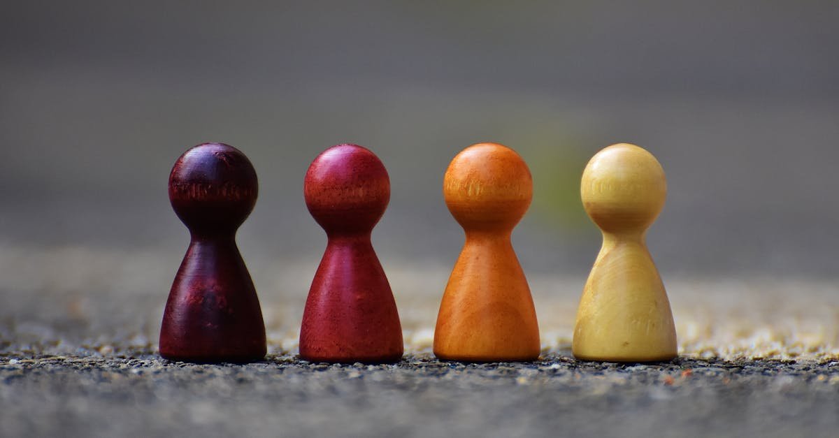 Close-up of four colorful wooden pawn pieces arranged in a row.