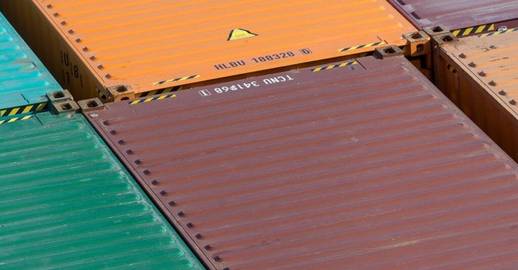 Aerial view of vibrant cargo containers arranged in a pattern, emphasizing logistics and transportation.