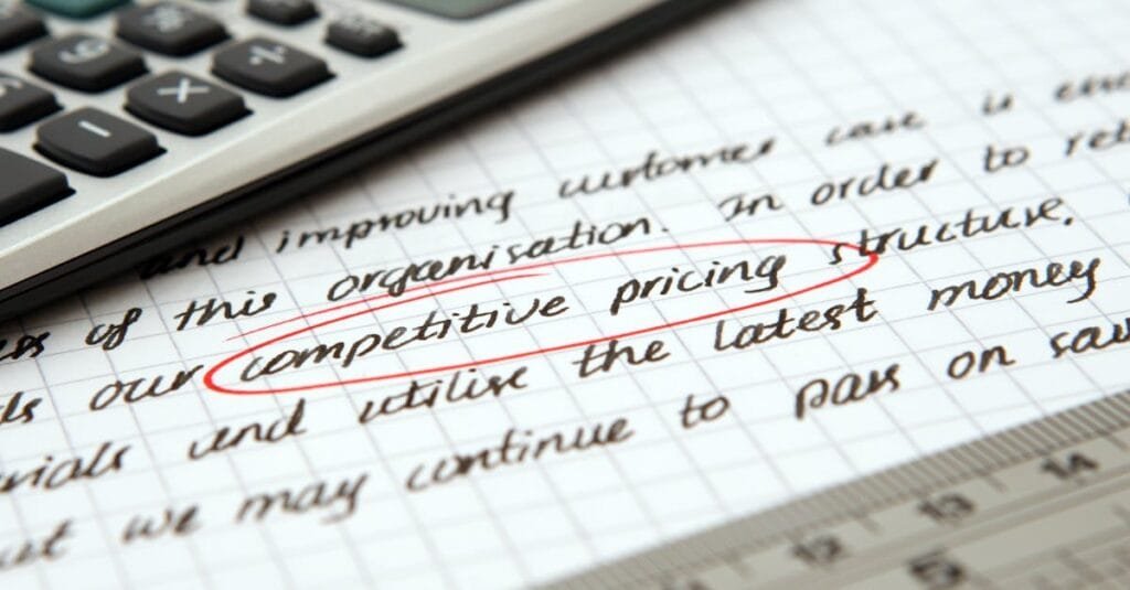 Focused image of handwritten business notes with calculator emphasizing pricing strategy.