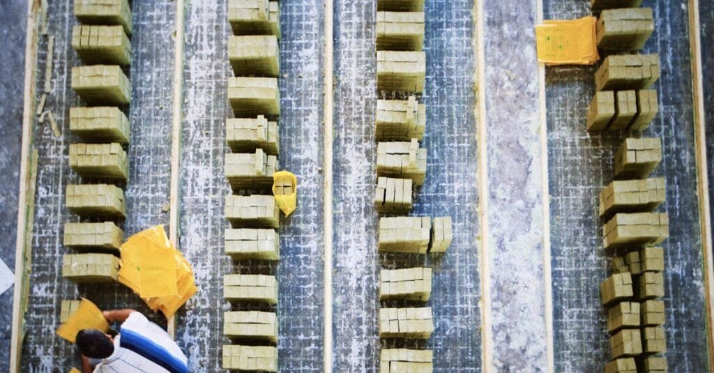 Aerial shot of a worker in a soap factory organizing bars of soap on production lines.
