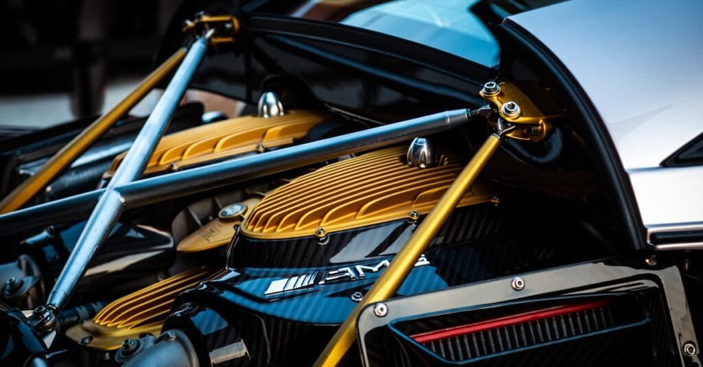 Detailed view of a luxury hypercar engine with gold and carbon fiber elements.