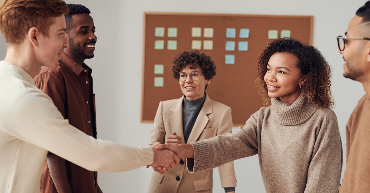 A diverse group of colleagues shaking hands during a productive office meeting.