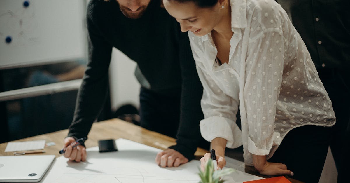 Two colleagues engage in a creative brainstorming session at the office, working together on new ideas.