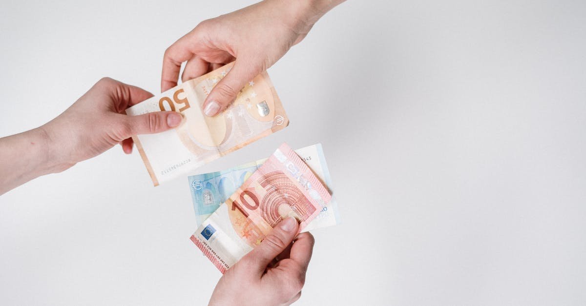 Close-up of hands exchanging euro bills, symbolizing finance and transaction.