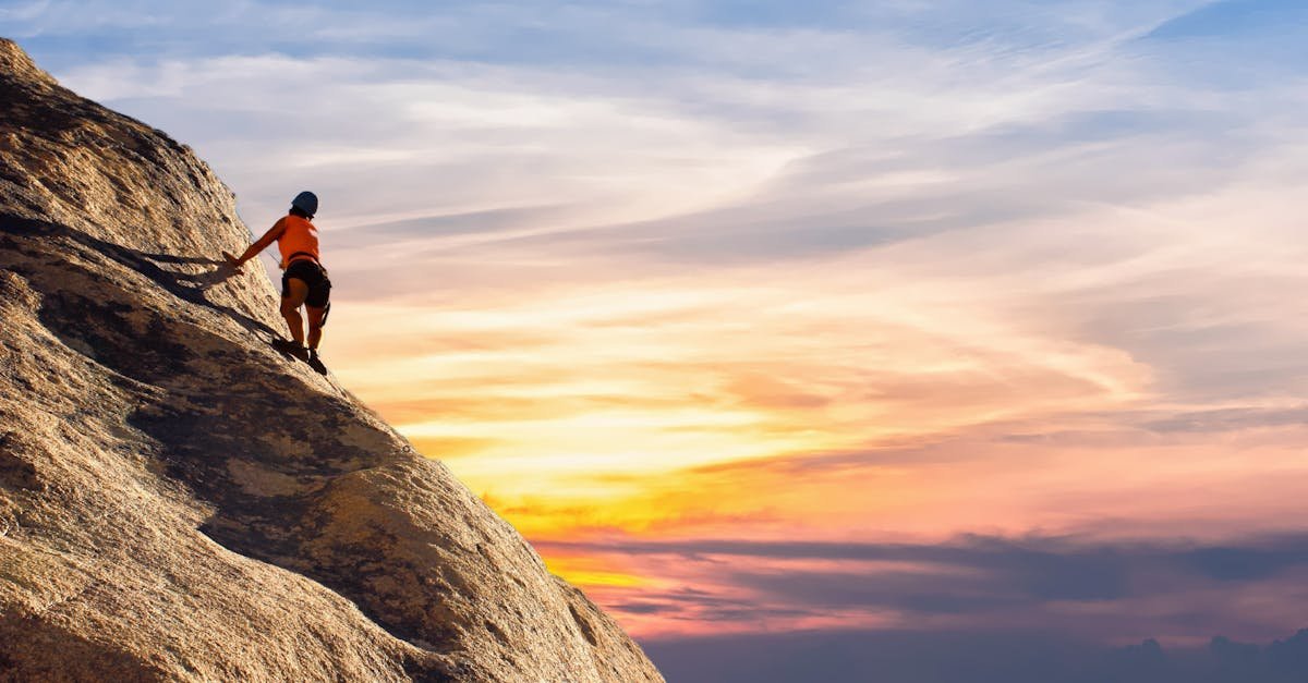 Climber conquers rock face at sunset, embracing the thrill and challenge.