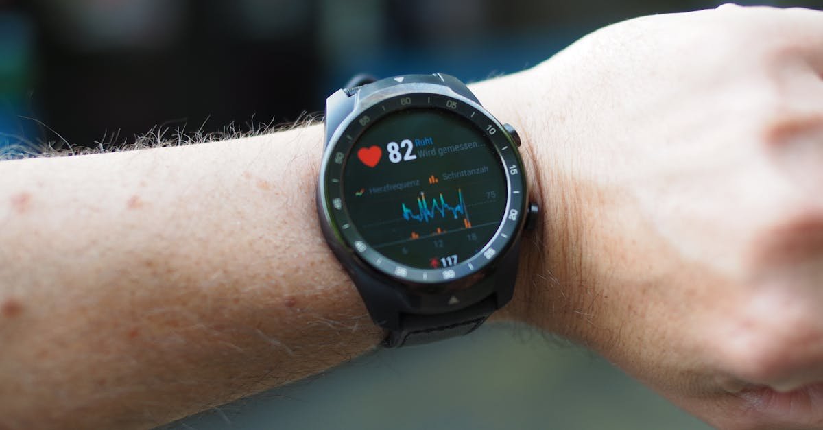 Close-up of a smartwatch showing heart rate and data on a person's wrist outdoors.