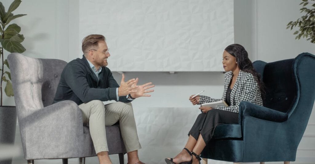 A candid interaction between a man and woman during a professional interview in a modern office setting.