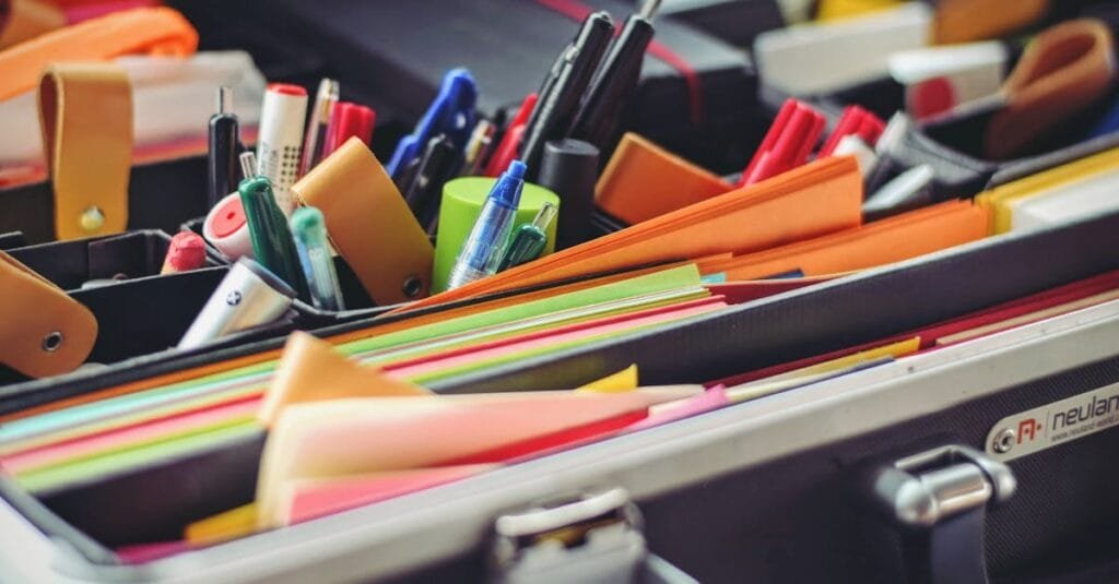 A collection of colorful office supplies neatly arranged in a suitcase, perfect for professionals on the go.