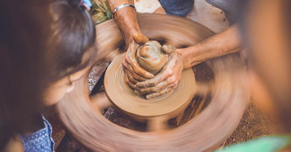 Close-up of hands shaping clay on a pottery wheel, capturing the artistry of crafting.