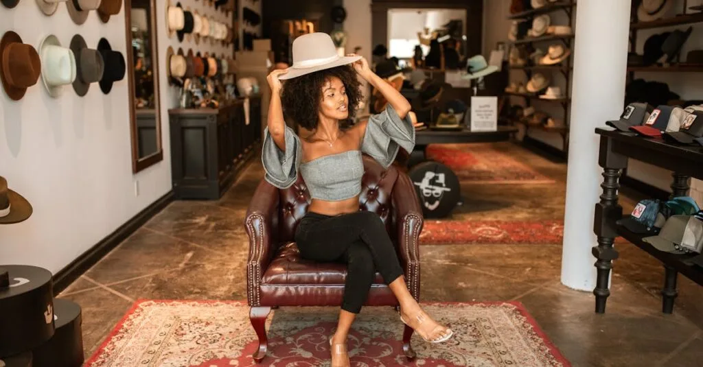 A woman in a chic boutique tries on hats while sitting on a leather chair, showcasing a fashionable interior.