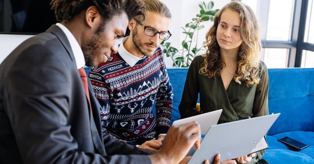 A diverse group of young professionals engaged in a business meeting inside a modern office.