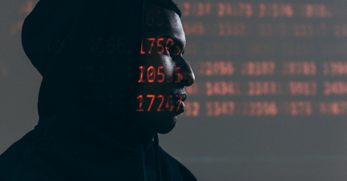 Side profile of a man in a hoodie, surrounded by red code, depicting cybersecurity theme.