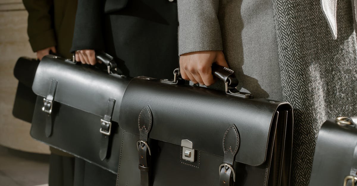 Group of adults holding sleek leather briefcases in formal business attire, emphasizing corporate professionalism.