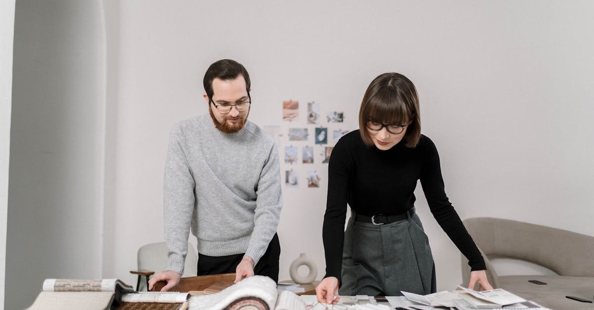 A man and woman reviewing fabric swatches, engaged in an interior design project.