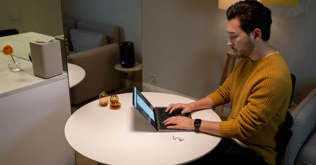 A man in a yellow sweater works on a laptop at home, creating a cozy and modern atmosphere.