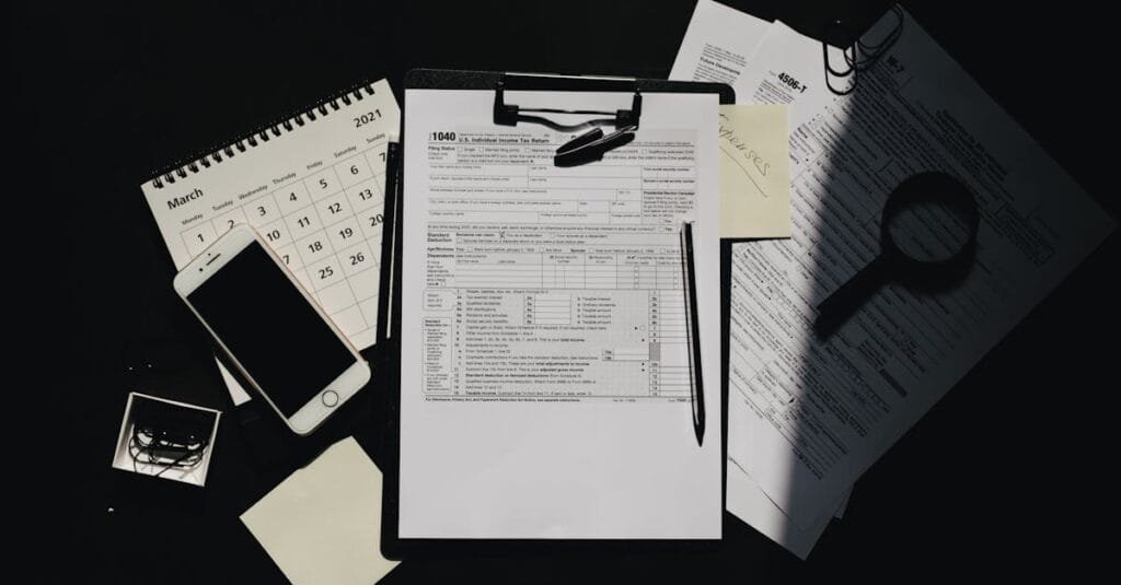 Flat lay of tax documents, calendar, and smartphone on a dark surface, symbolizing tax preparation.