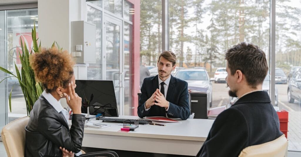 Three adults in a modern office setting having a professional business meeting.