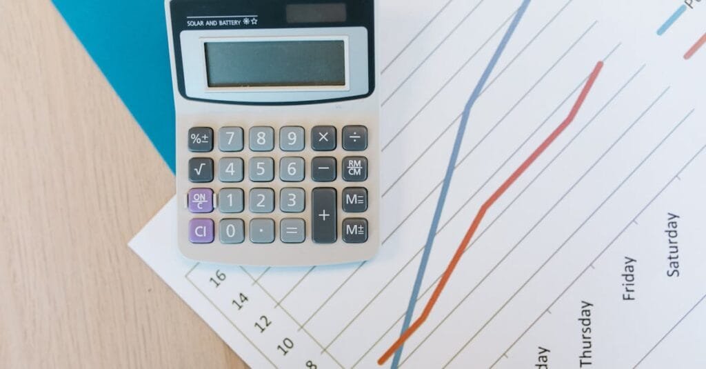 Top view of calculator and graph paper on office desk, perfect for business themed visuals.