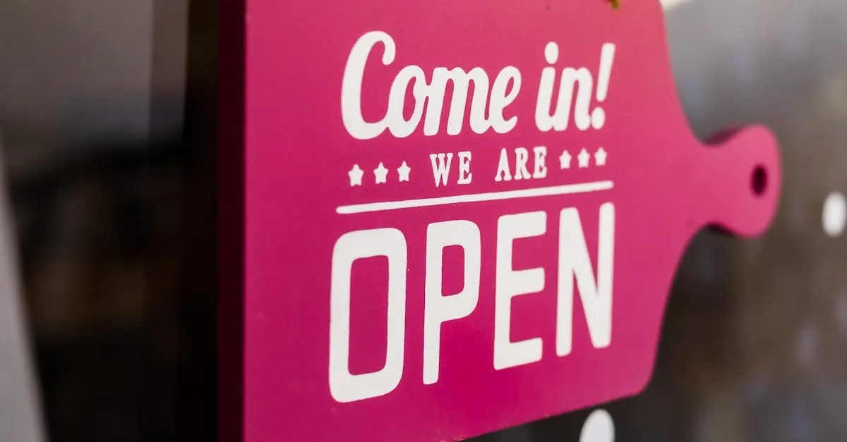 A bright pink "Come in! We are Open" sign hanging in a store window welcoming customers.