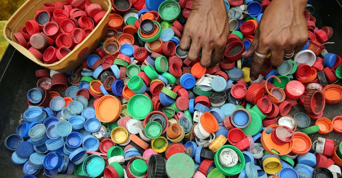 A vibrant assortment of plastic bottle caps being sorted by hand for recycling in Manila.