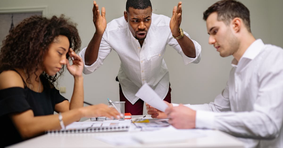 Three colleagues in a heated argument at the office, highlighting workplace stress.