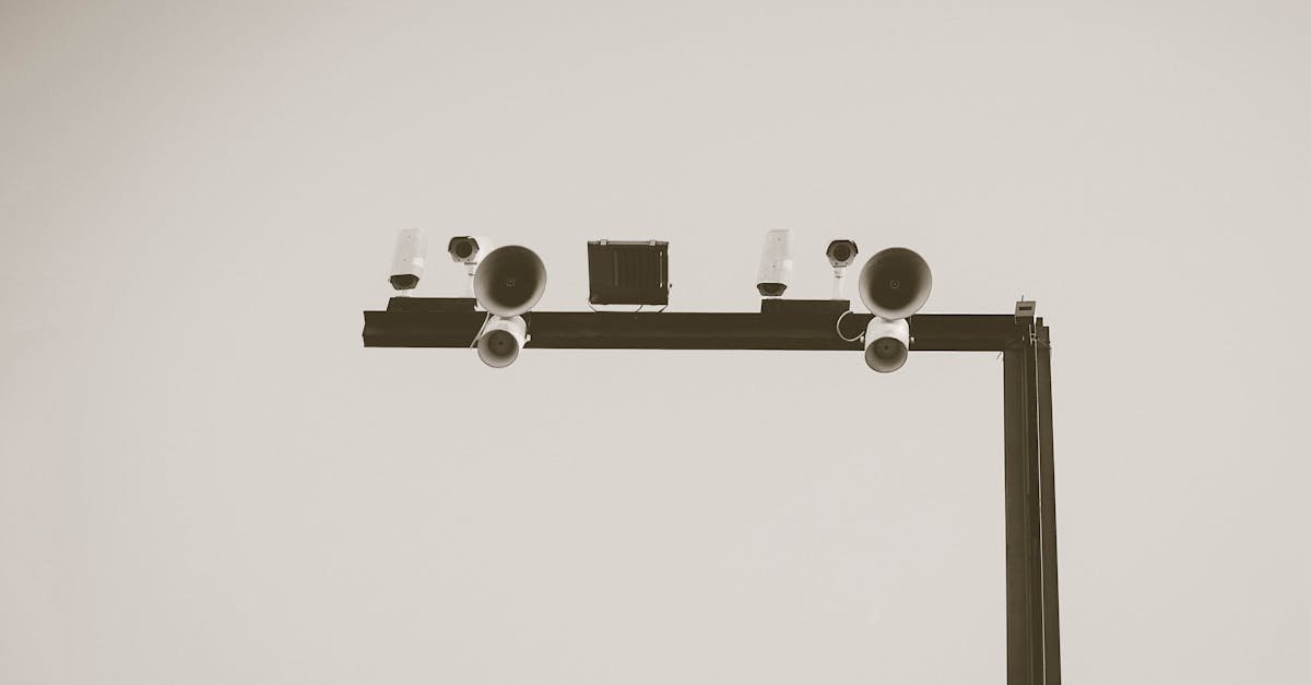 Monochrome image of CCTV cameras and speakers on an outdoor metal frame in Barcelona.