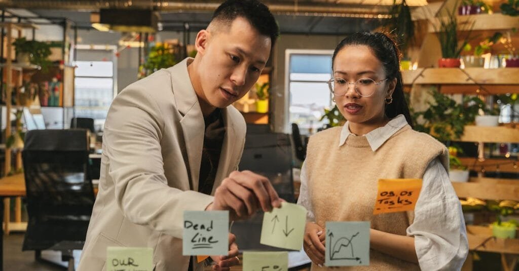Two professionals engaging in strategic planning with sticky notes in a modern office setting.