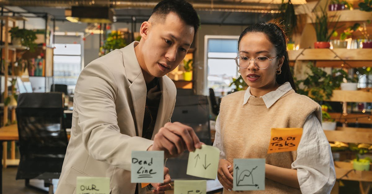 Two professionals engaging in strategic planning with sticky notes in a modern office setting.