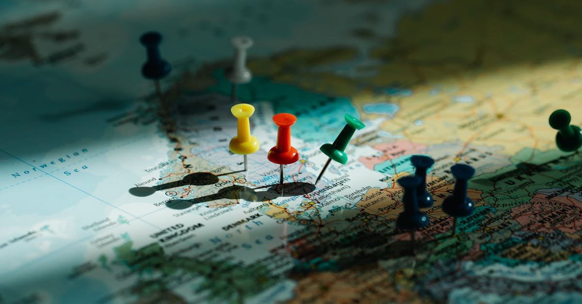 A close-up view of colorful push pins marking locations on a detailed world map.