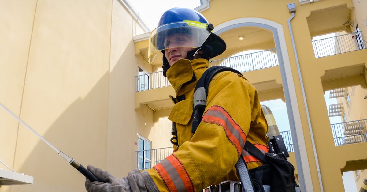 A firefighter in full protective gear operates outdoors in an urban setting, ensuring safety and protection.
