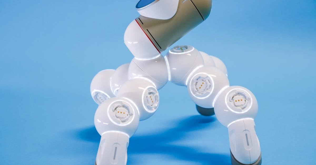 A close-up view of a futuristic robotic device against a blue background.