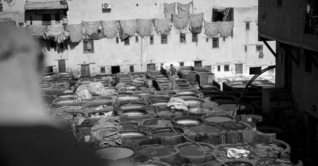 Black and white photo of a traditional tannery in Morocco with drying hides.