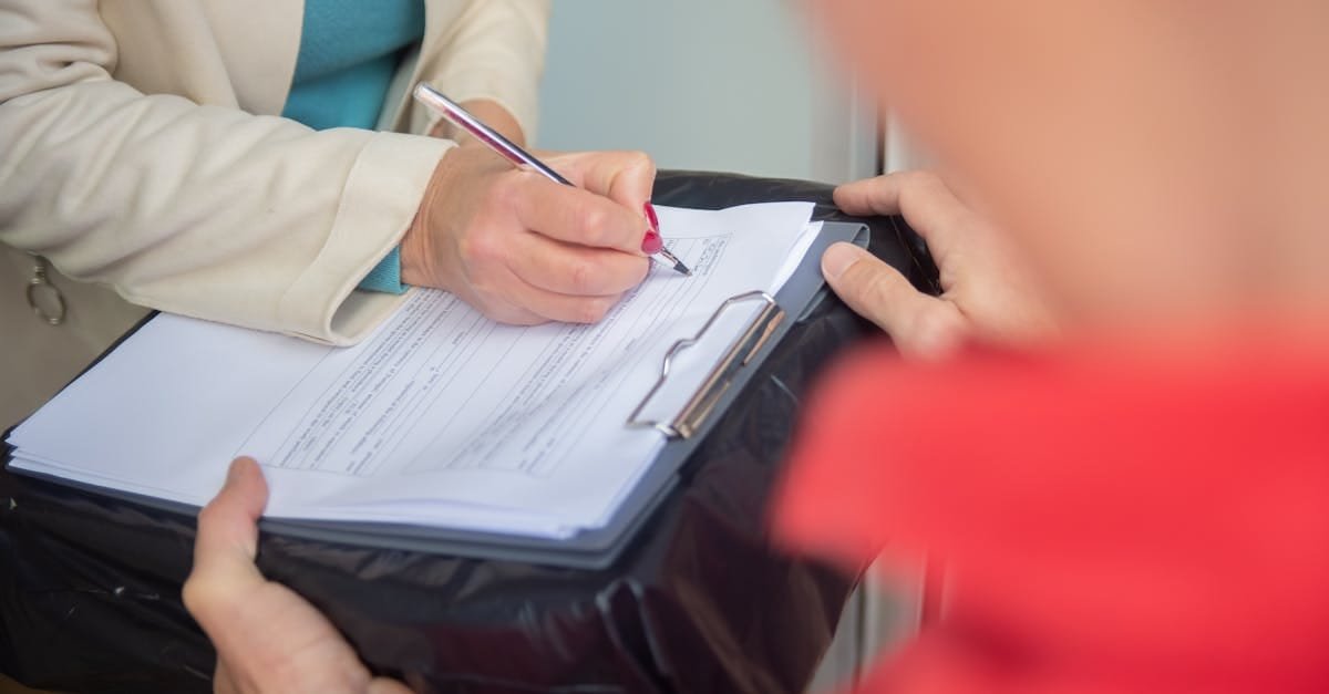 Focused image of hands signing an important document on a clipboard, illustrating a business agreement or delivery process.