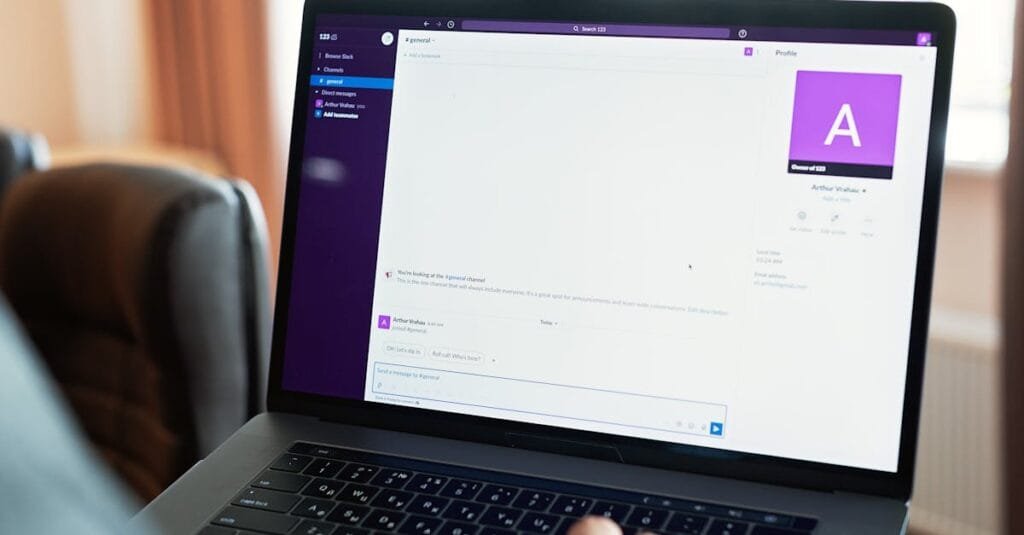 Person using a laptop with an online communication platform, showcasing modern work tech.